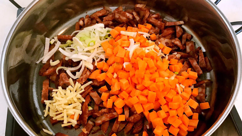 香菇腊肠焖饭,加入葱姜和胡萝卜，翻炒均匀