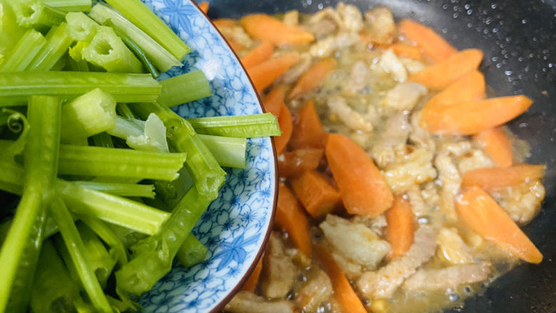 芹菜炒胡萝卜,倒入芹菜