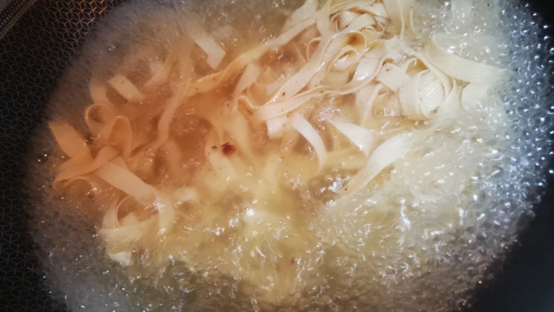 香辣豆皮,水烧开后放入豆腐皮，大约5分钟煮熟，捞出放入碗中。