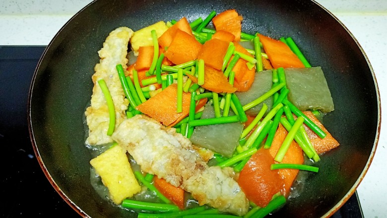 皮渣炒豆腐、带鱼、蒜苔、胡萝卜,翻炒均匀