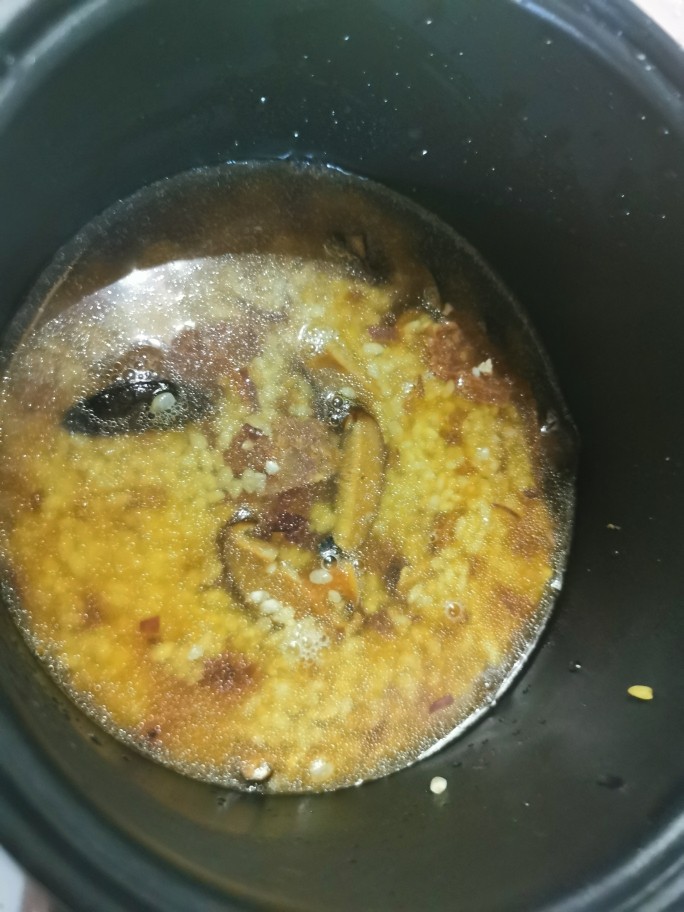 香菇腊肠焖饭,倒回电饭锅里，加入刚刚泡香菇的水，不够的话在加清水至平常煮饭的量，按下煮饭键