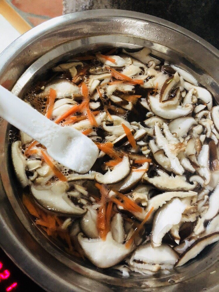 香菇豆腐汤,放入胡萝卜丝和香菇片，再放入适量盐，煮开。