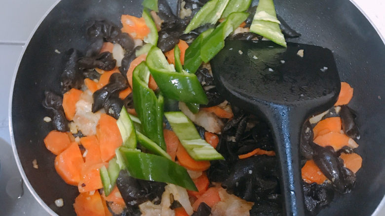 胡萝卜炒木耳,翻炒至胡萝卜变软后加入青椒。