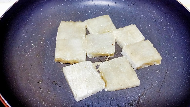 皮渣炒豆腐、蒜苔,锅中放入适量，皮渣煎至两面金黄