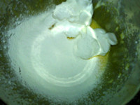 手指饼干,挖一半蛋白糊到蛋黄中，并筛入一半面粉，拌匀