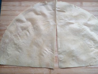 菜煎饼（韭菜鸡蛋馅）,将煎饼从中间的折痕切开成两个扇形。