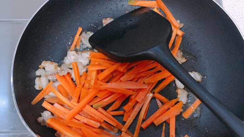 芹菜炒胡萝卜,放入胡萝卜翻炒。胡萝卜比较干需要撒少量开水。