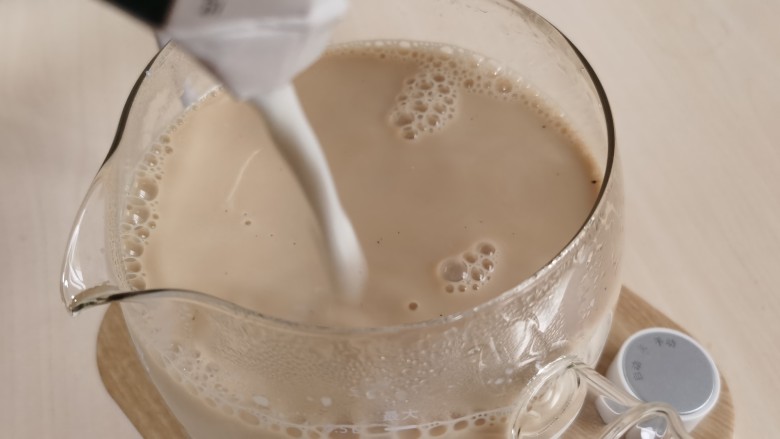 宅家自制珍珠奶茶,将牛奶加入煮好的红茶里。