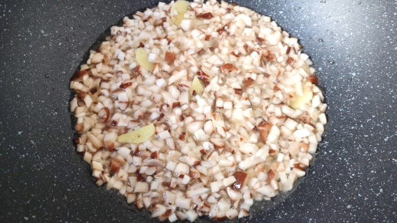 香菇腊肠焖饭,下入香菇碎翻炒至变软。