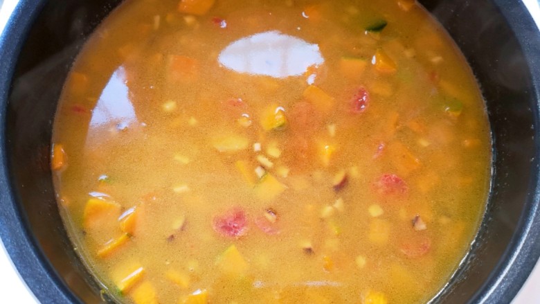 香菇腊肠焖饭,将炒好腊肠南瓜带汤汁一起倒进电饭锅里面，按下“煮饭”键。