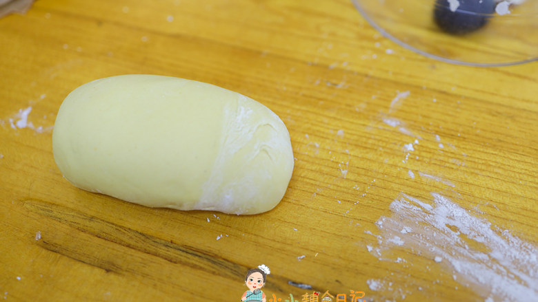 9个月以上辅食小黄人南瓜馒头,面包机里面取出黄色的南瓜面团，手揉一下至表面光滑