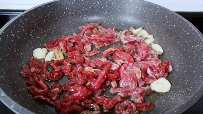 黑胡椒牛柳,锅里放油，油热放牛肉丝大火翻炒。