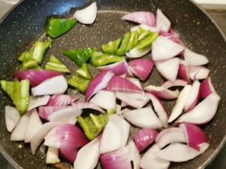 黑胡椒牛柳,锅中放入1勺食用油 油热后放入青椒和洋葱 翻炒断生