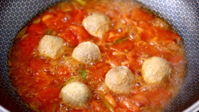 番茄丸子烩年糕,翻炒至番茄变软后，锅中加入适量的清水烧开，放入鸡肉撒尿丸，大火继续煮10分钟。