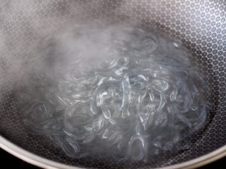 蒜香手撕包菜粉条,锅中倒入适量的清水，放入红薯粉条煮熟捞出备用。