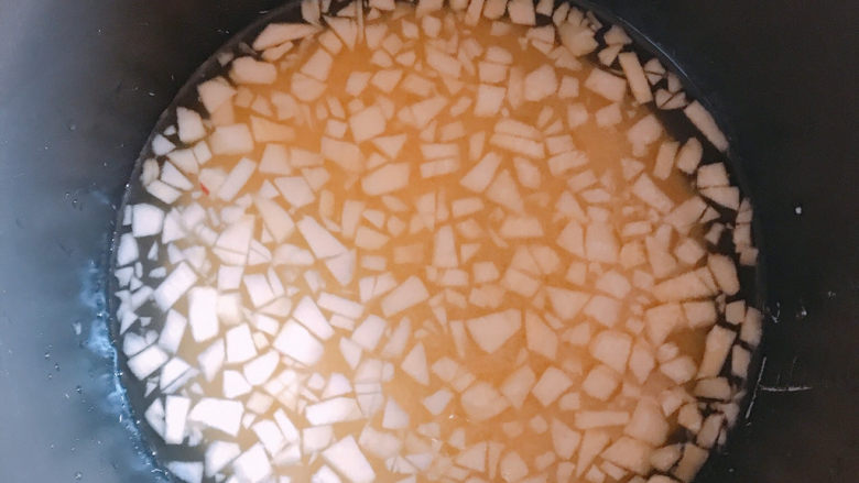 苹果小米粥,把小粒的苹果加入到电饭锅中。并加入适量清水，然后选择煮粥键