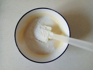 小米发糕,将打好的米糊倒入碗中，筛入10克低筋面粉，翻拌均匀