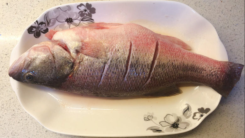 清蒸鲈鱼,在鲈鱼上抹上适量的盐，淋上<a style='color:red;display:inline-block;' href='/shicai/ 718'>料酒</a>，腌制十分钟左右。