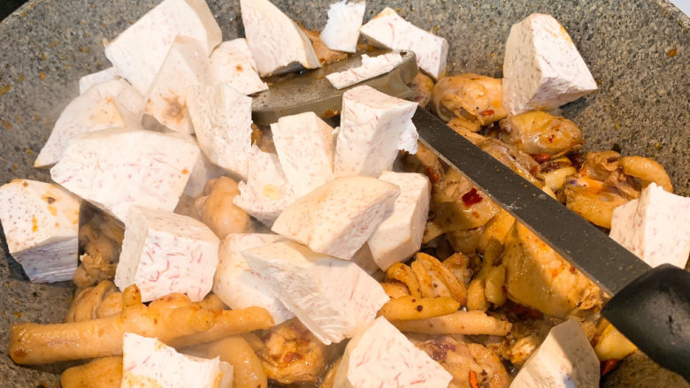 芋头烧鸡,再放入芋头块，翻炒均匀，再加入开水，盖过鸡肉，放入1勺盐，3根小米椒。盖上锅盖中小火炖25分钟，即可出锅