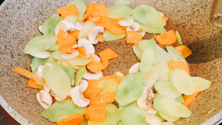 香菇胡萝卜炒莴苣,放入准备好的红萝卜，百香菇，莴苣，翻炒均匀