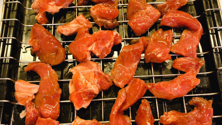 三眼荷包蛋叉烧饭,烤箱预热230度，把腌制好的猪肉放在架子上铺平，腌制猪肉的汁留着备用