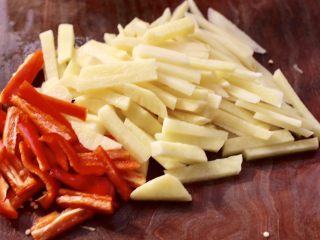 红虾芹菜土豆小炒,土豆去皮后洗净，用刀切成粗条，红椒去籽后切成粗丝。