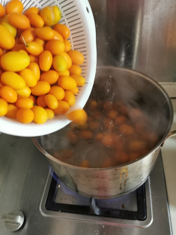 咸金桔【腌制方法】,烧开一锅清水，把金桔放进去煮过，水稍沸腾，桔子变得饱满光亮就可以（大概1一2分钟），不要把桔子煮熟。