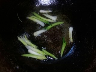 炒合菜,炒锅倒油，放入葱白段小火炒香。