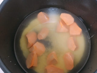 小米红薯粥,把红薯和小米还有糖放进电饭煲，加入适量的水，按下煮粥键。
