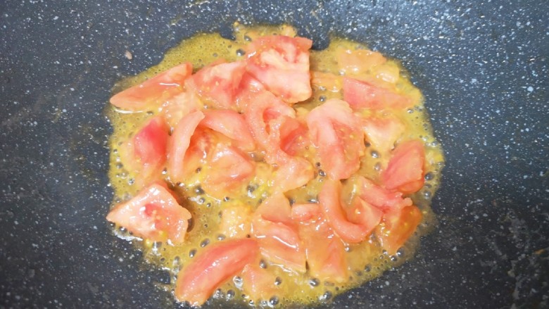 金针菇牛肉卷,炒锅内倒适量的食用油烧热，下入西红柿翻炒至出汁。