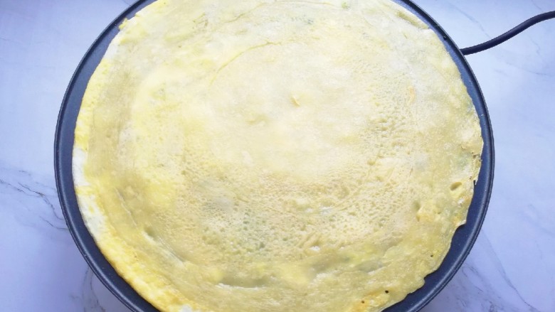 玉米渣煎饼,待蛋液凝固以后，将煎饼翻面。