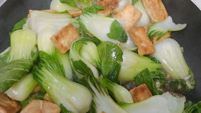 油菜豆腐,加入少许的酱油和开水翻炒均匀。等到上海青变色，再加入少量盐就可以起锅了。