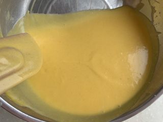 芒果慕斯蛋糕,将融化有吉利丁片的芒果泥分三次加入打发好的淡奶油中，不断搅拌，混合均匀。