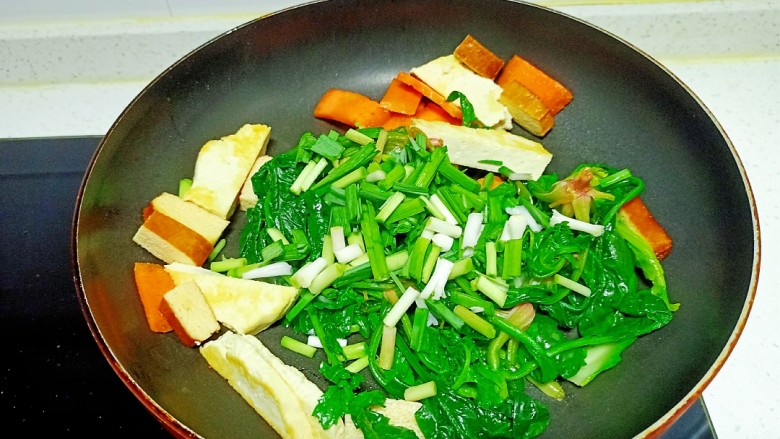 豆腐、豆干炒菠菜,放入盐、蒜苗
