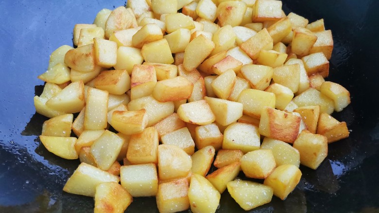 孜然火腿土豆丁,另起锅放少许油，放土豆丁煎至表面焦黄盛出。