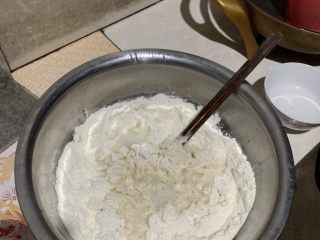 韭菜素包子,温水化开酵母倒入面粉中搅成絮状。
