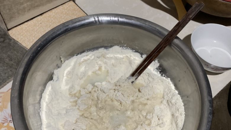 韭菜素包子,温水化开酵母倒入面粉中搅成絮状。