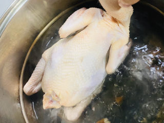 家庭版白切鸡,水开放入鸡，浸泡全身。
