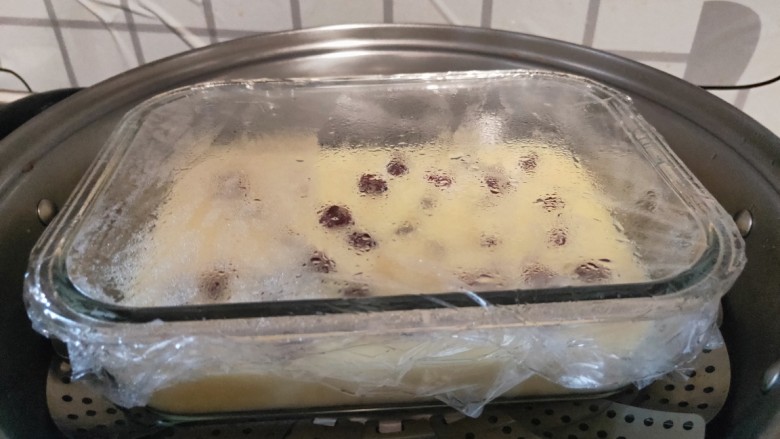 蔓越莓蛋糕（蒸）,盘子封上一层保鲜膜，用牙签扎上10个小孔。水开后放入锅中中火蒸25分钟即可出锅。