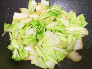 大白菜炖粉条,下入白菜叶翻炒均匀。