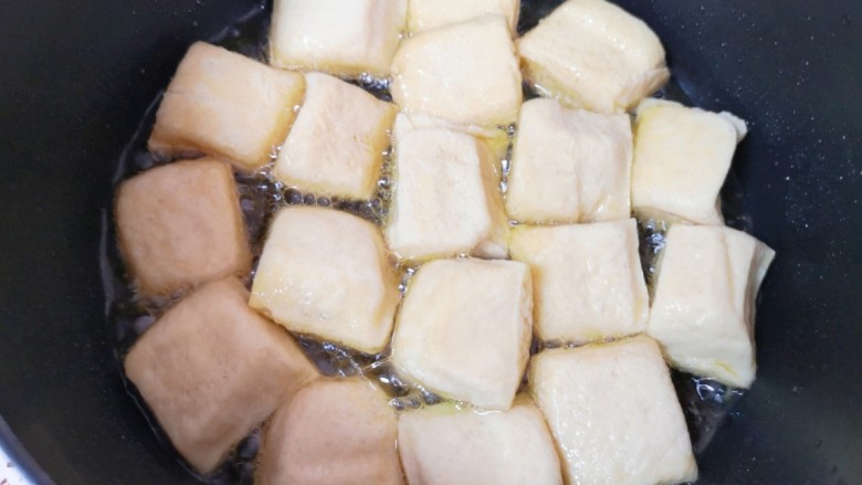 油菜豆腐,炸锅里倒多一点食用油烧热，放入小豆腐。