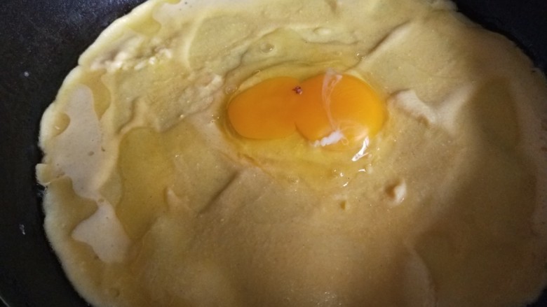 玉米渣煎饼,第二个煎饼摊好面糊很快就干了，打入一个鸡蛋摊均匀效果更佳。