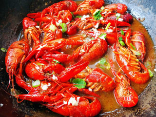 蒜香小龙虾,汤汁烧的差不多时撒上少葱花、香菜、蒜提鲜即可出锅享用
