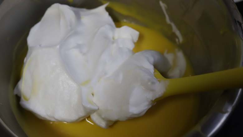 牛奶戚风,先取三分之一的蛋白霜加入蛋黄糊里，用刮刀上下翻拌均匀，不要搅动。