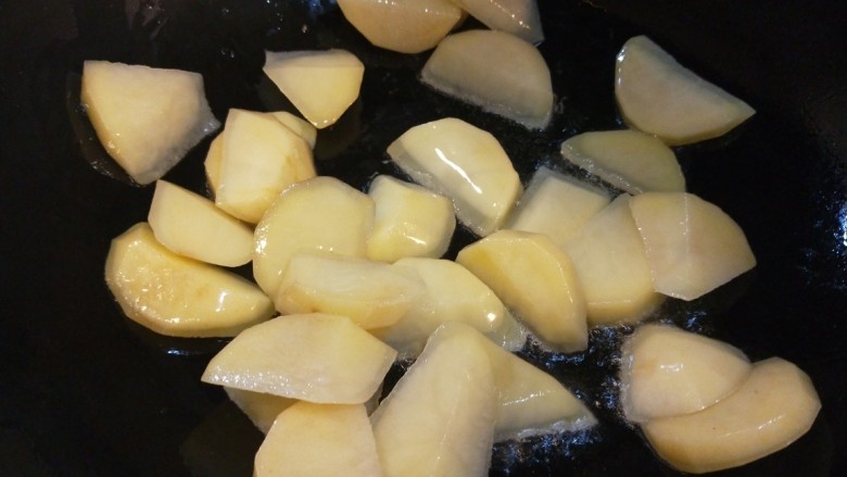 辣白菜炒土豆片,锅中倒入适量油烧热，倒入土豆片翻炒。