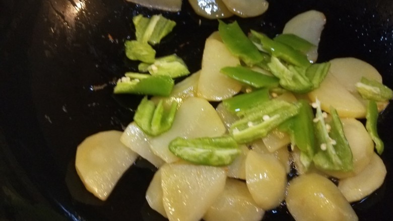辣白菜炒土豆片,炒制土豆片熟透放入尖椒配色。