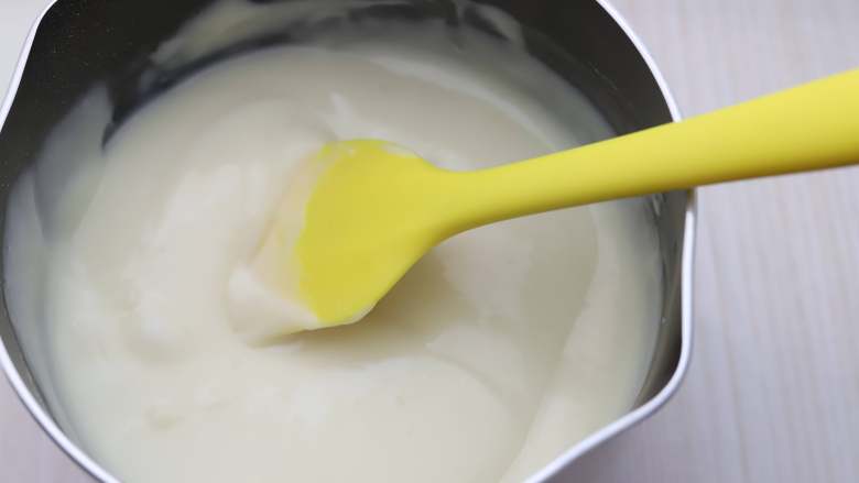 炸鲜奶,将奶锅至于灶上，小火，一边加热一边搅拌，搅拌的时候用这种硅胶刮刀比较顺手，很快牛奶就会变得浓稠了，到了浓稠的状态就关火，把奶锅从灶上拿下来。