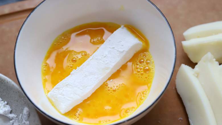 炸鲜奶,把鲜奶条放入玉米淀粉里滚一下，然后放入蛋液中，沾一层鸡蛋液.