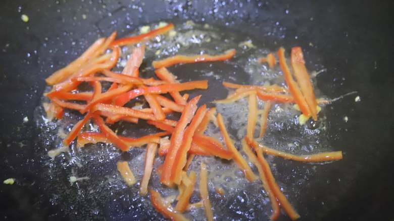 春韭菜炒鸡蛋,把红辣椒丝放入炒过鸡蛋的锅中翻炒，让红辣椒断生。