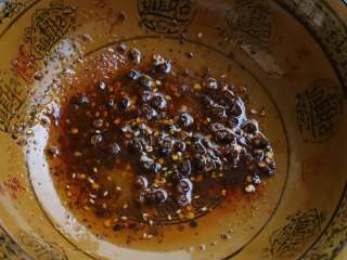 香菜木耳,在一个大碗中放入辣椒料，放入一些花椒，浇上一勺热油，激发出花椒和辣椒的香味。